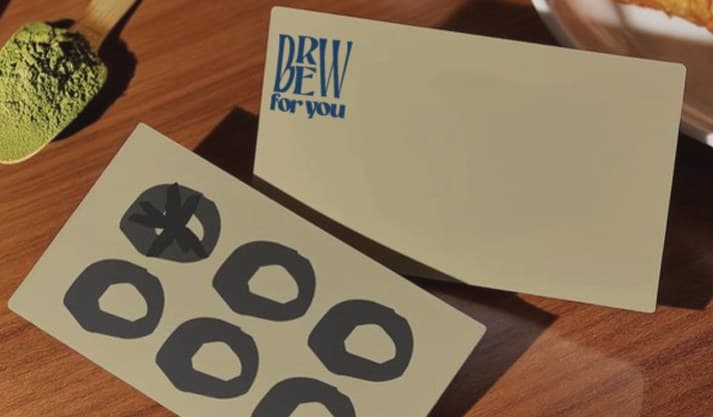 Brew for You loyalty and business cards next to matcha powder