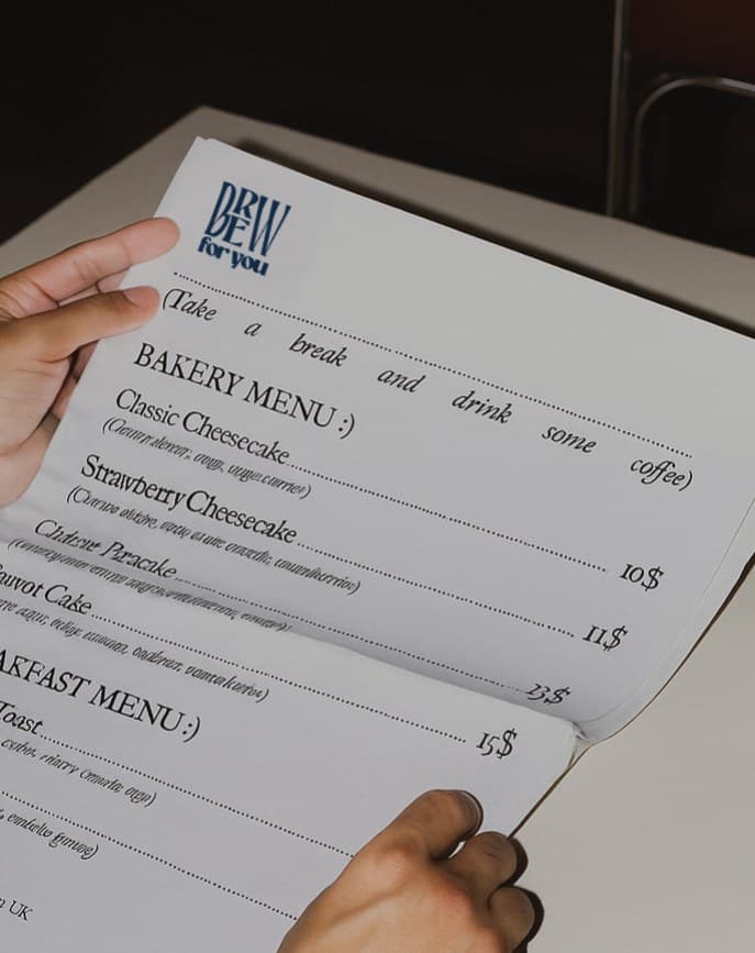 Hands holding the Brew for You bakery and breakfast menu