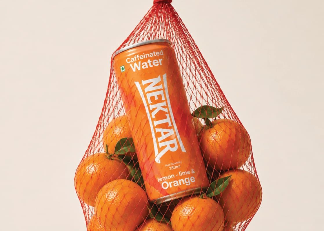 A can of Nektar lemon-lime & orange in a red net bag of oranges