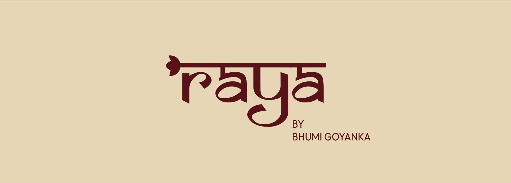 The Raya logo, “raya by Bhumi Goyanka”, in maroon on sand