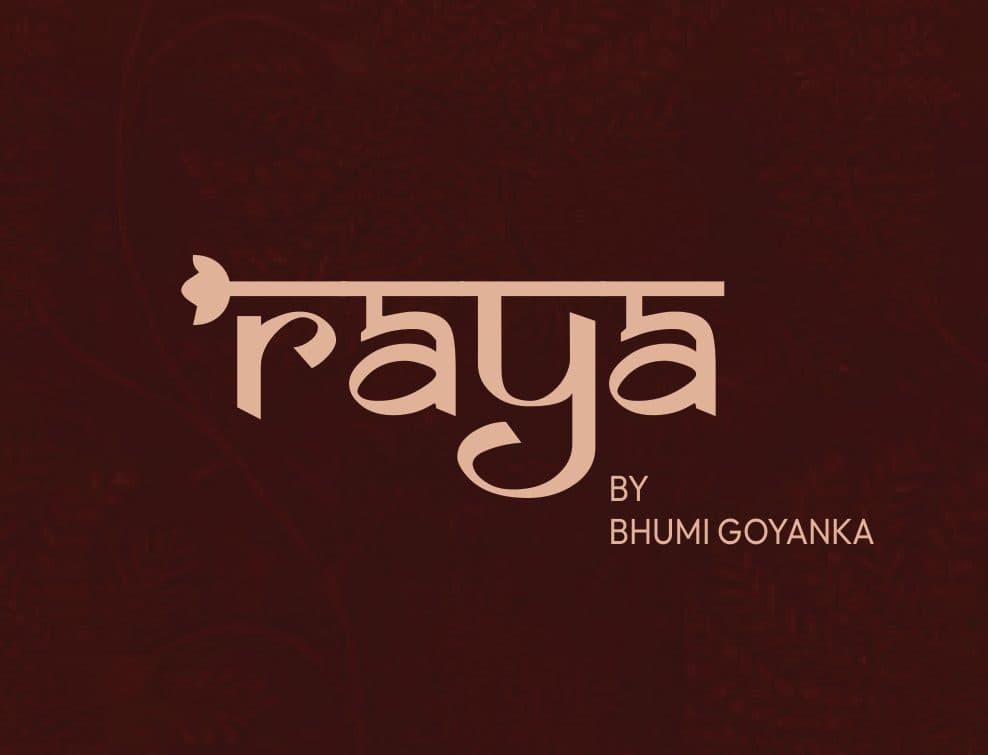 The Raya logo, “raya by Bhumi Goyanka”, in blush on maroon