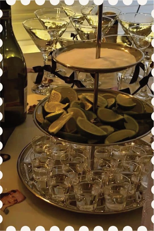 A tiered stand of lime wedges and shot glasses on the bar, framed as a postage stamp