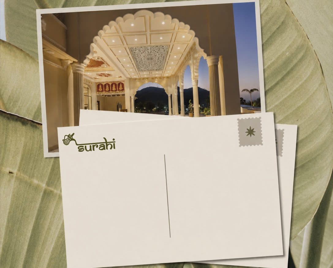 Surahi postcards over banana leaves, one showing the resort’s domed pavilion
