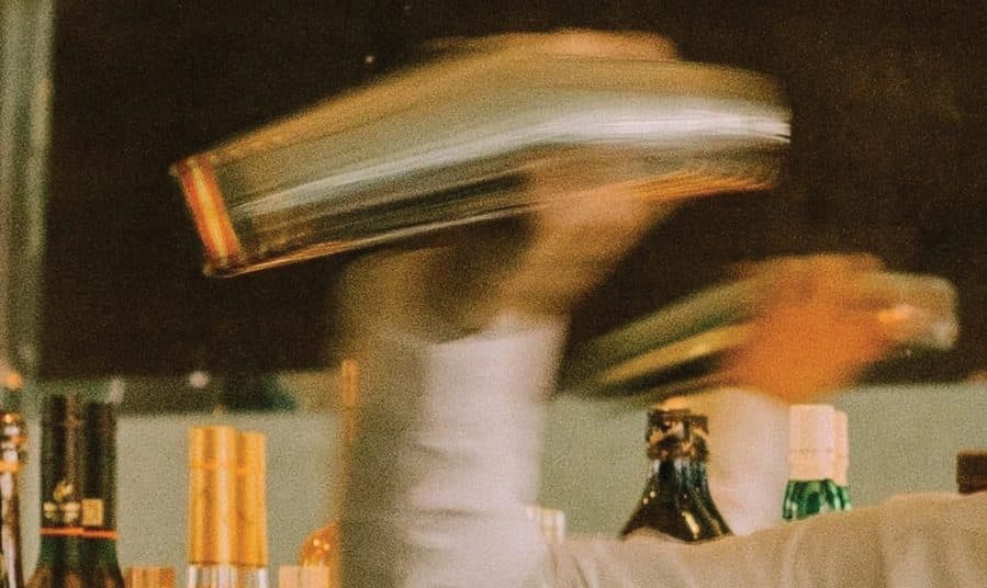 A bartender’s cocktail shaker, blurred mid-shake
