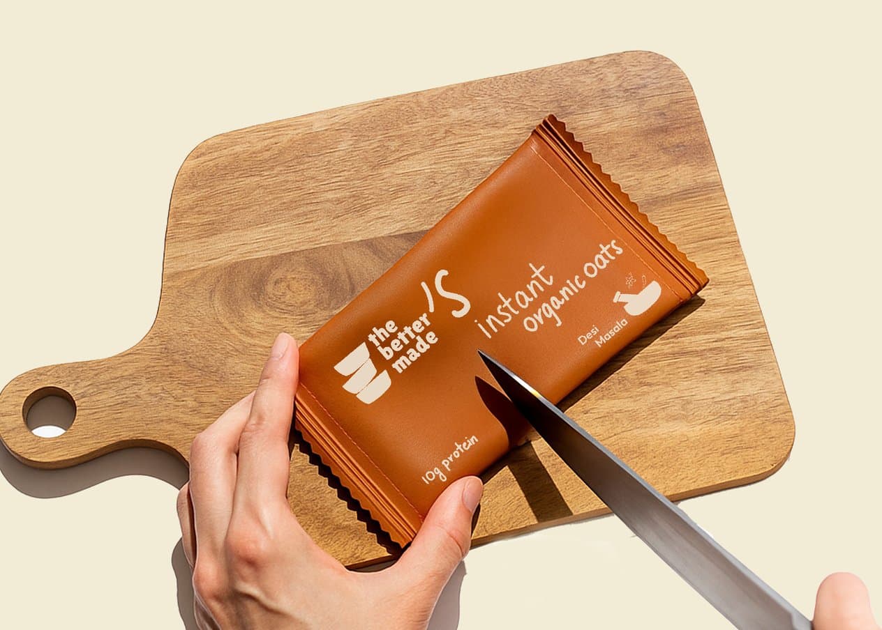 A hand cutting open a sachet on a wooden board