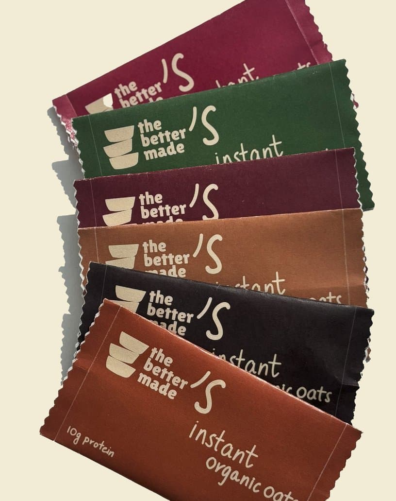 Sachets of instant organic oats fanned out, from maroon and green to brown and rust