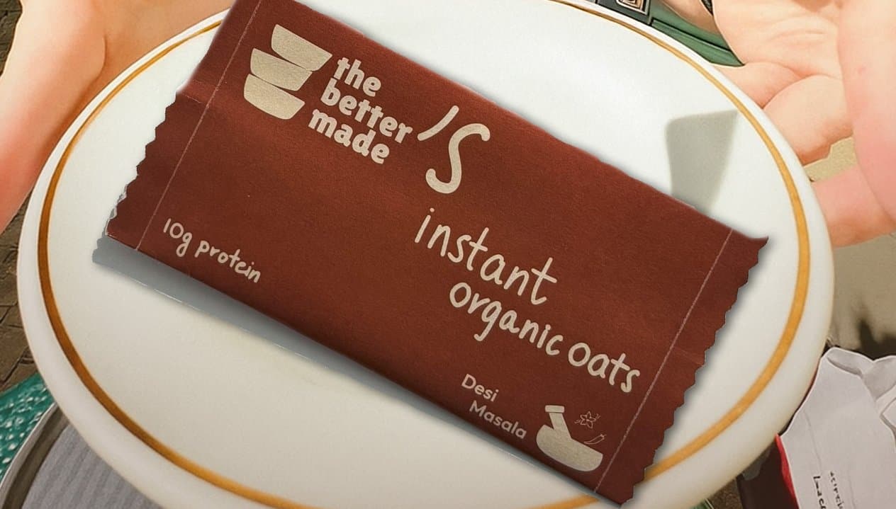 A rust sachet of instant organic oats on a gold-rimmed plate